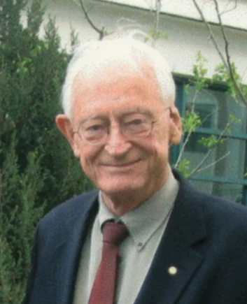 Alan MacDiarmid smiling in the complete supplied institutional portrait.
