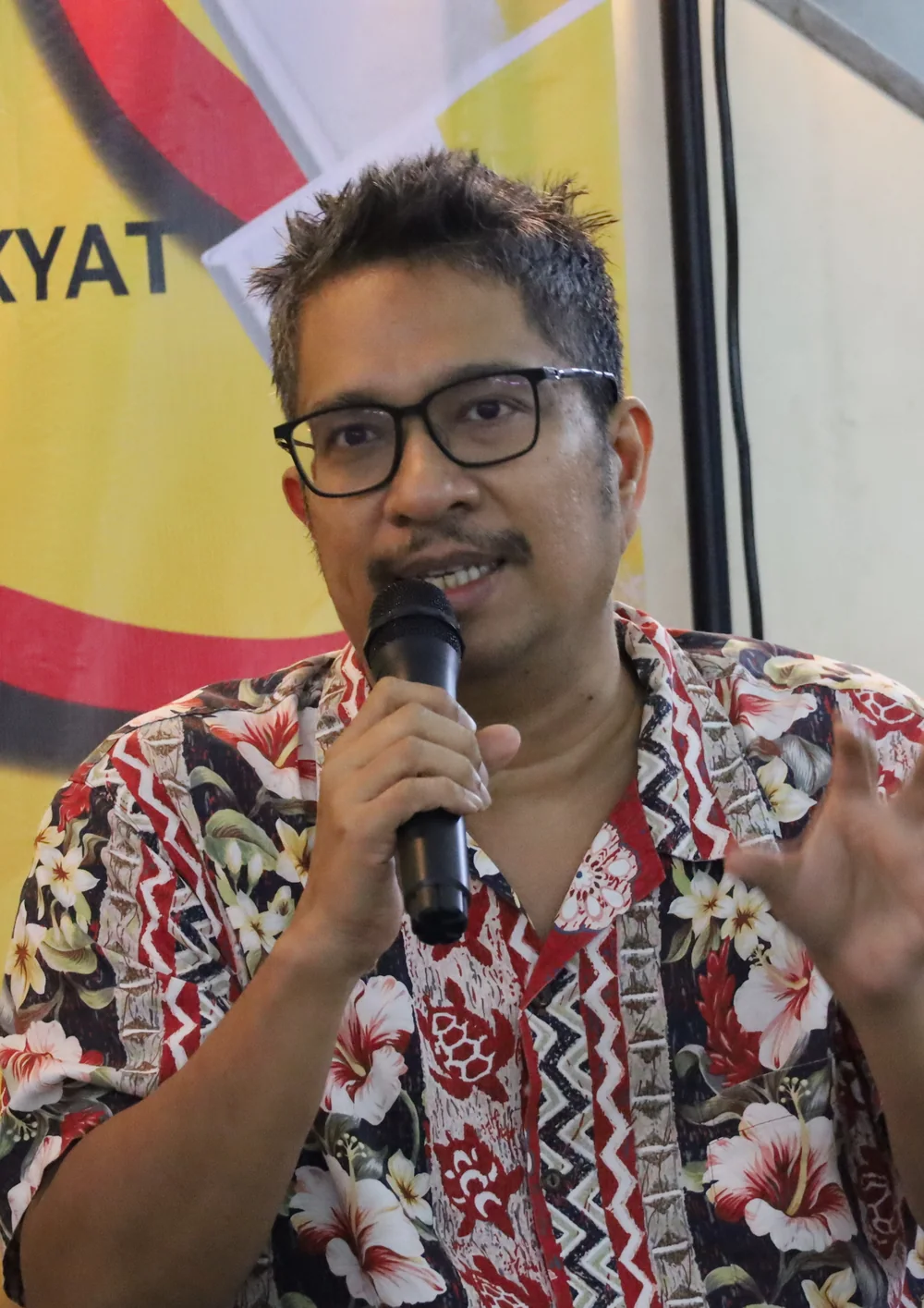 Amir Muhammad holding a microphone at the Hentian Buku Selangor opening event in December 2024.