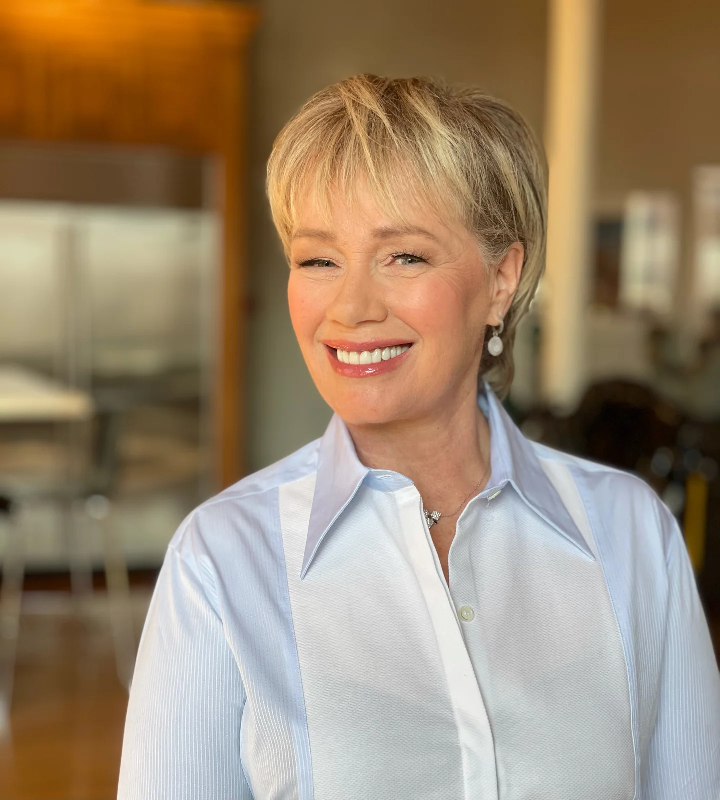 Arlene Dickinson smiling in a light blue shirt in the complete 2021 portrait.