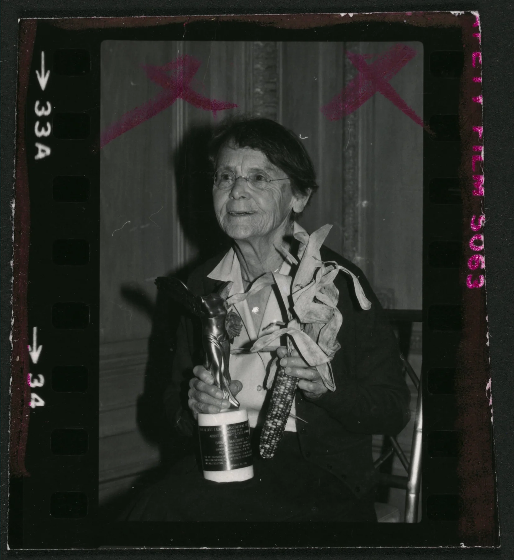 Barbara McClintock holding her Lasker Award and an ear of maize, with the original photographic border and markings retained.