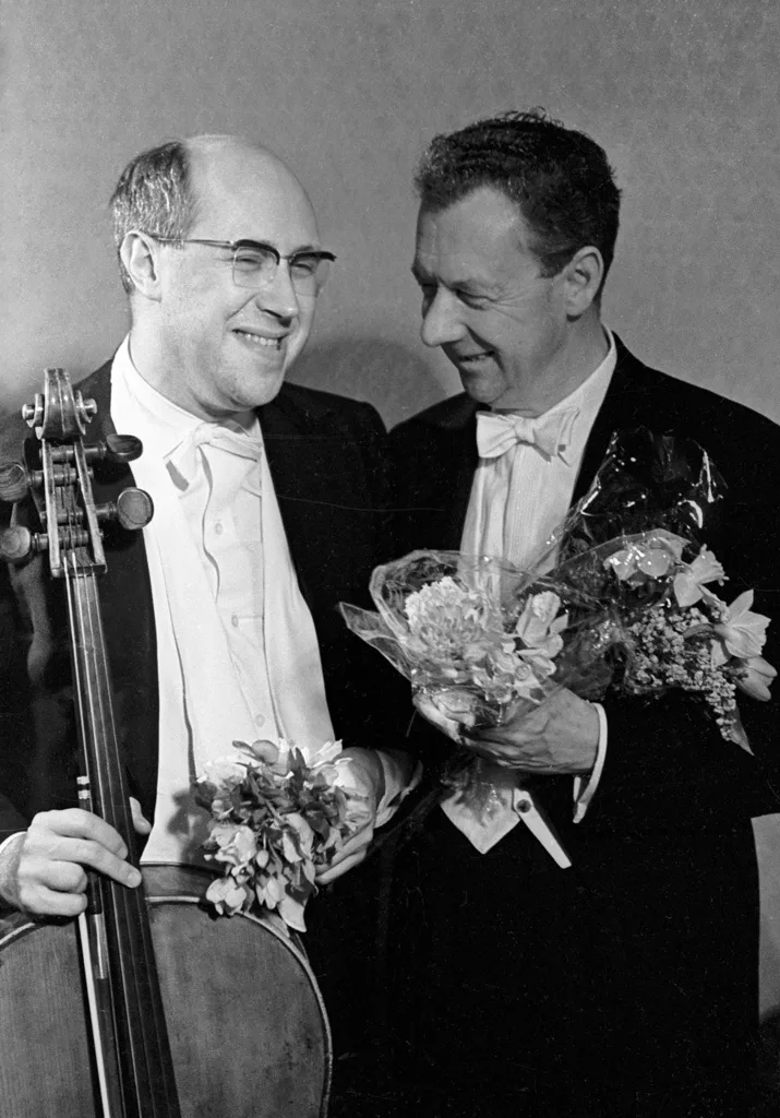 Benjamin Britten on the right holding flowers, beside cellist Mstislav Rostropovich in Moscow in 1964, with both musicians and the full photograph retained
