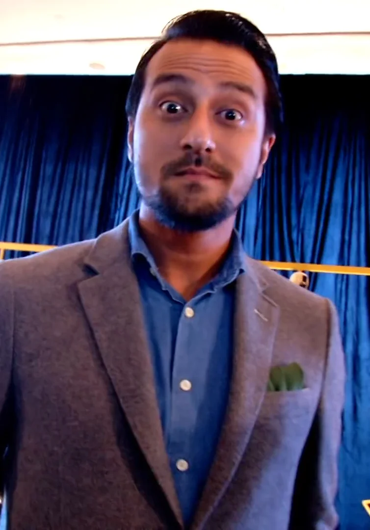 Bront Palarae in a jacket and blue shirt in MeleTOP’s Oscars Breakfast With Stars video, March 2016.