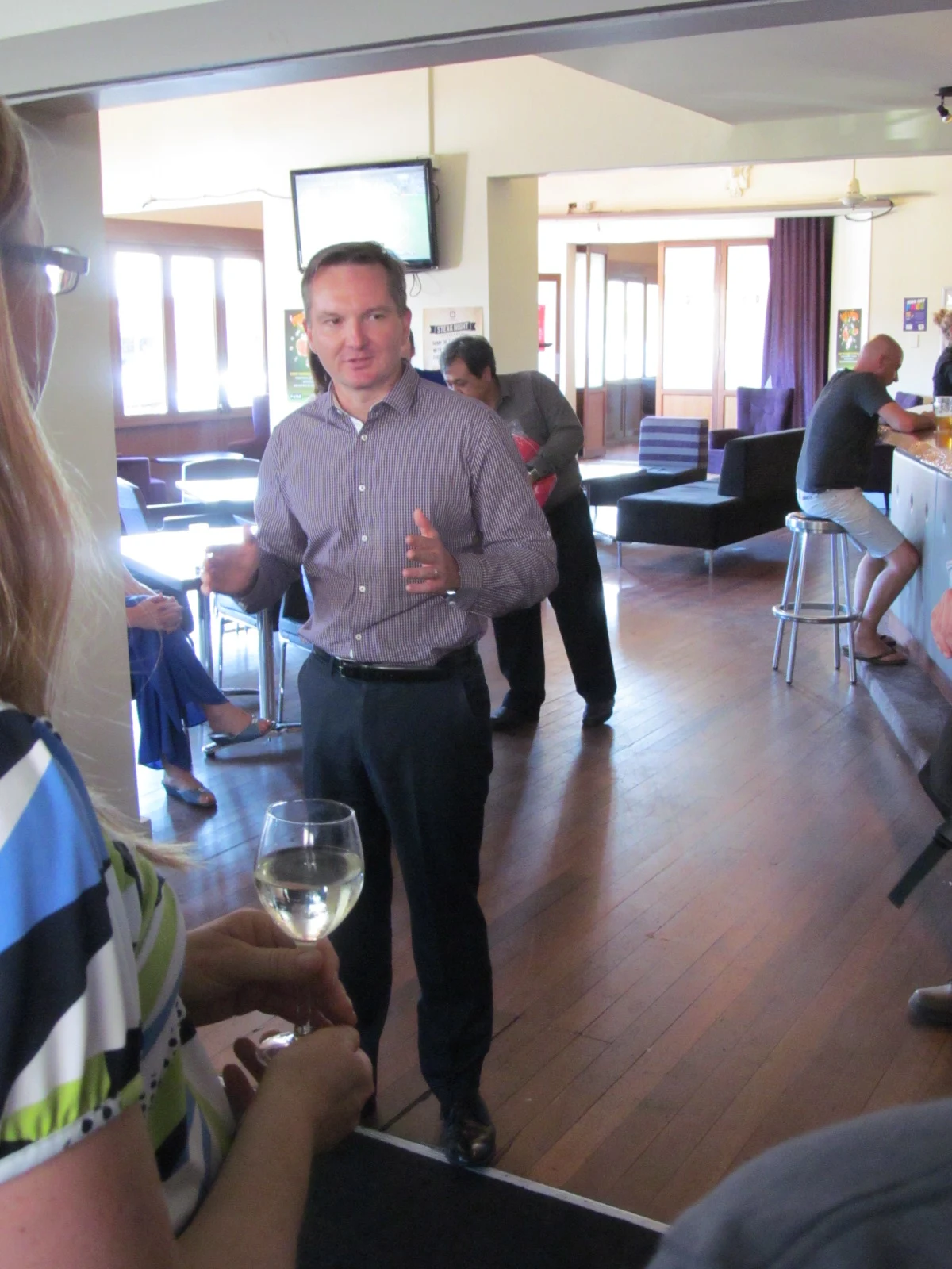 Chris Bowen standing and speaking to people at a WA Labor Summer Forum gathering in Perth, with the complete room and foreground people retained.