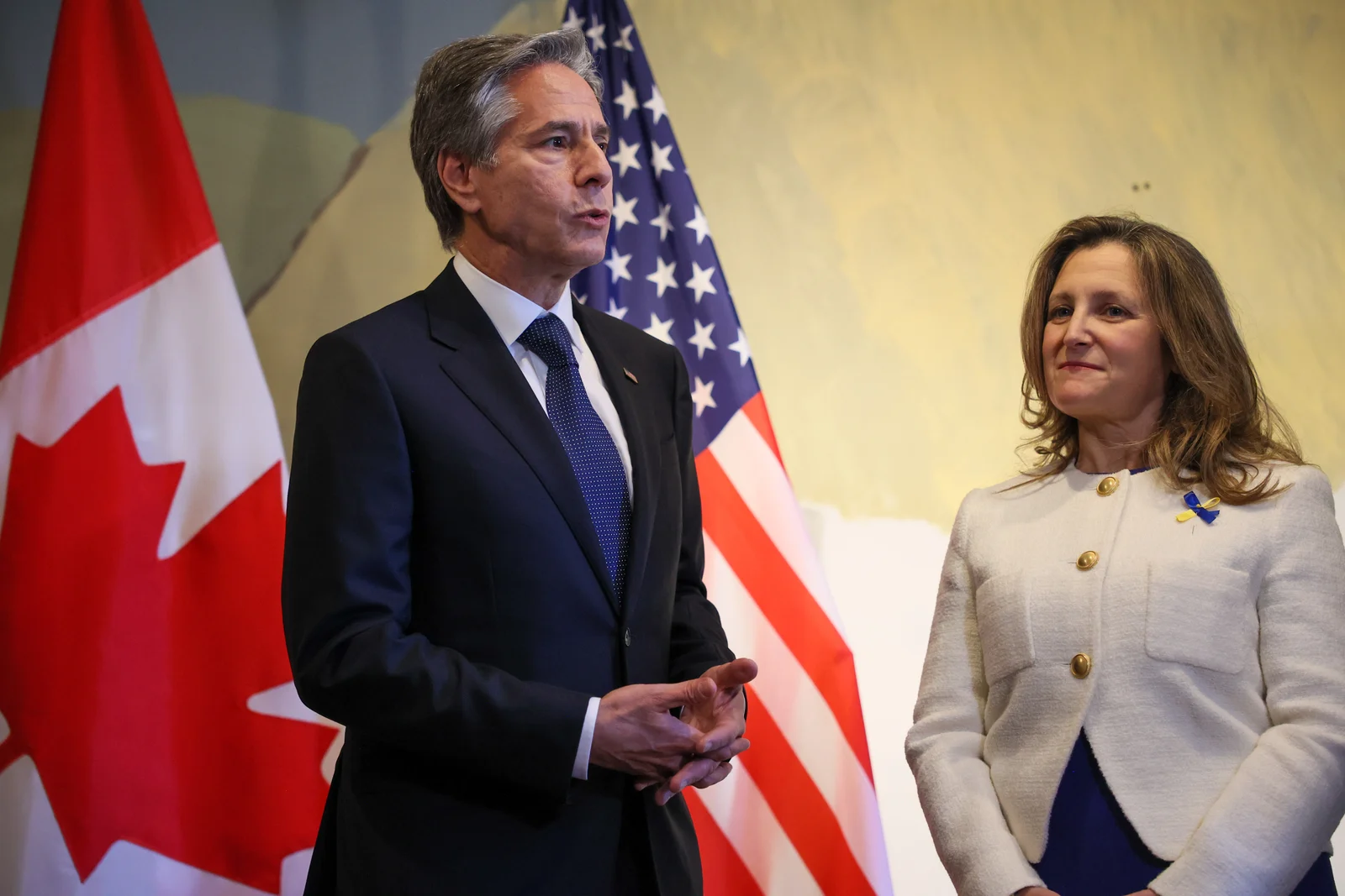 Chrystia Freeland at right beside Antony Blinken, with Canadian and American flags, at Café Ukraine in Ottawa in October 2022