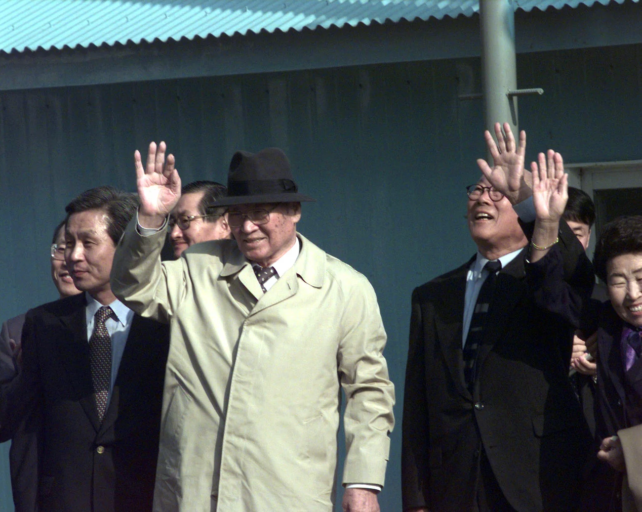 Chung Ju-yung, in a light trench coat and black hat, waves at Panmunjom on 27 October 1998.