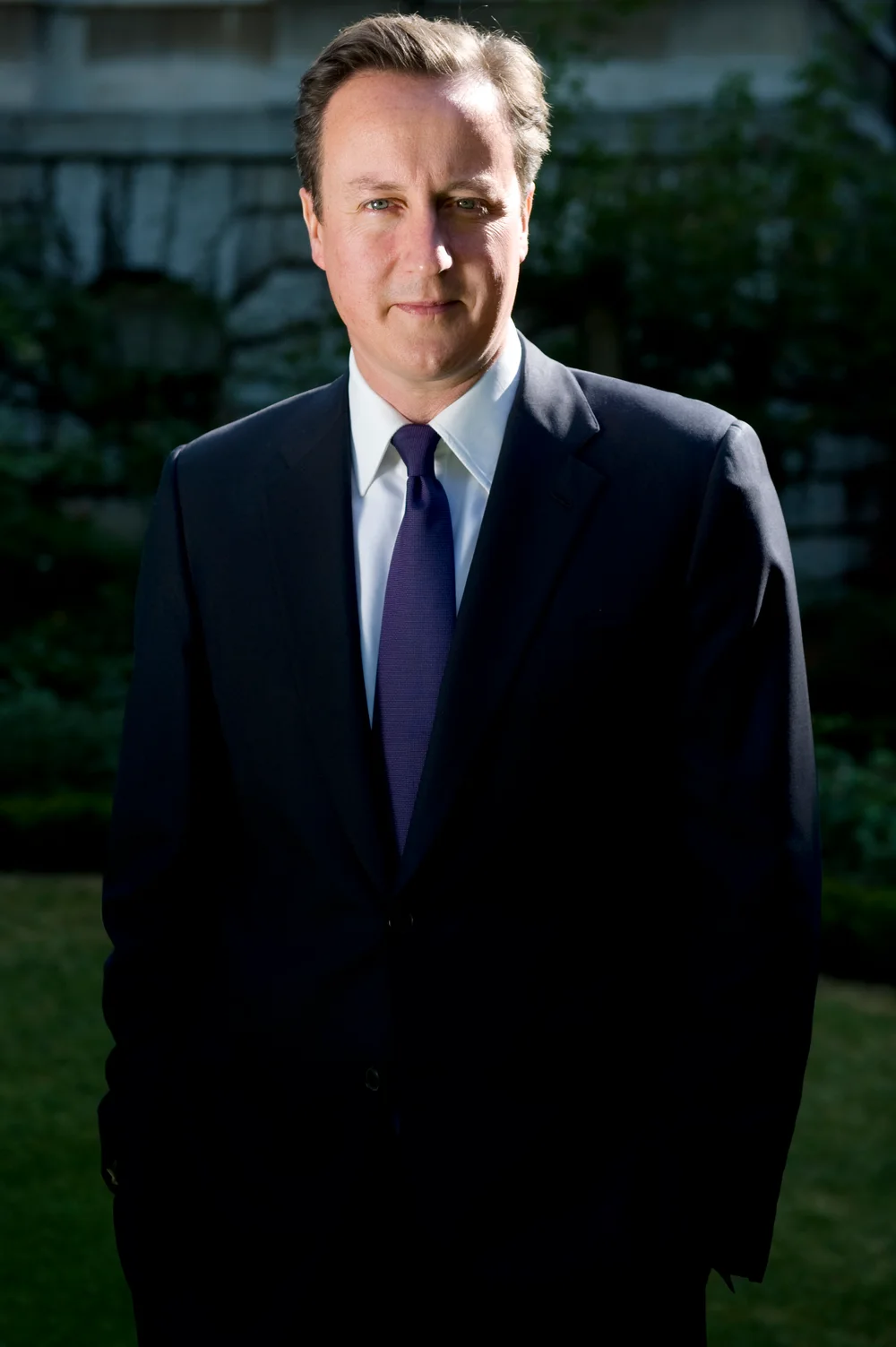 Complete official photograph of David Cameron standing in a dark suit outside Downing Street in 2010.