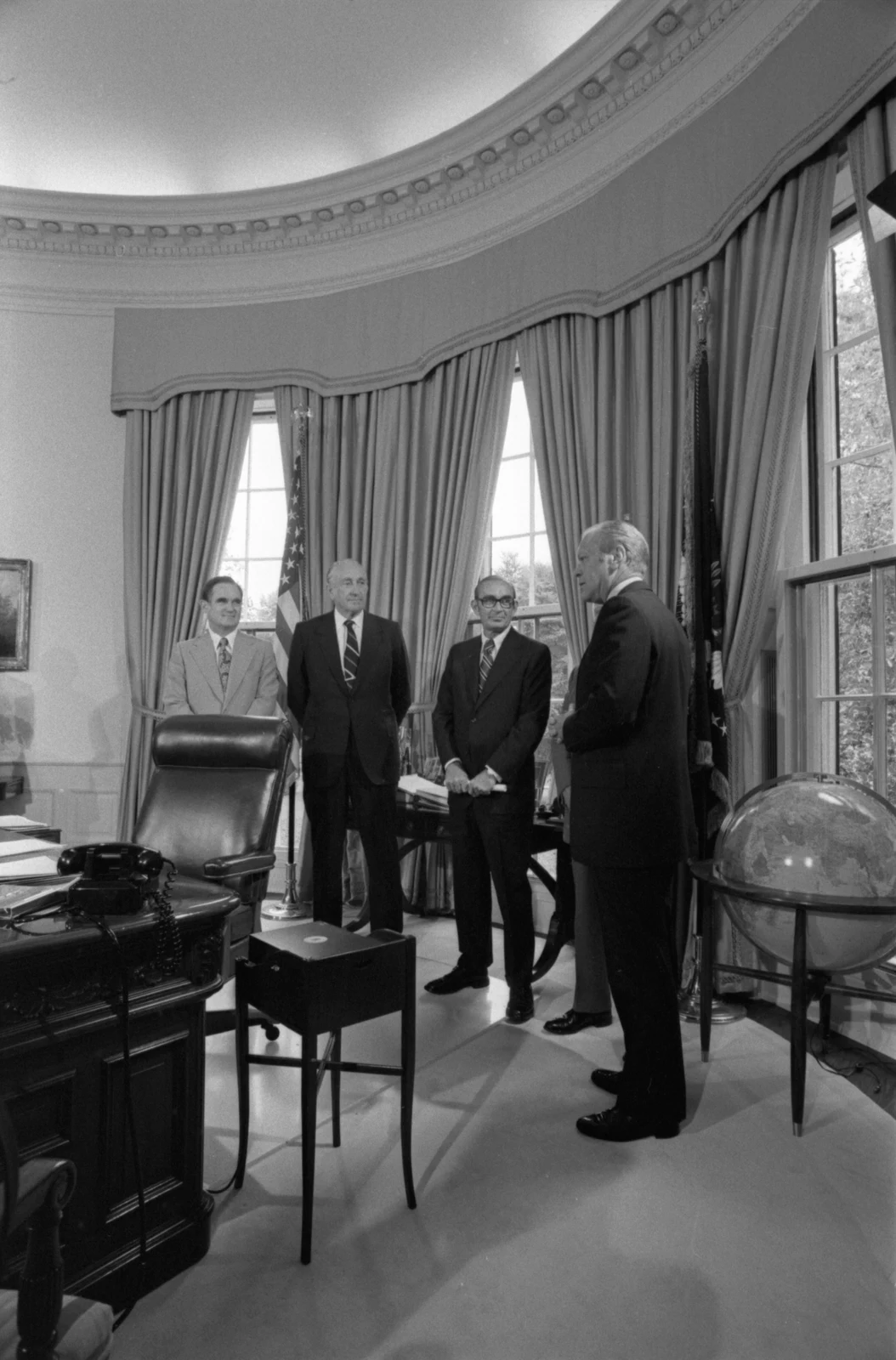 David Packard, second from left, standing with Gerald Ford and others in the Oval Office on 8 July 1975; complete vertical White House frame