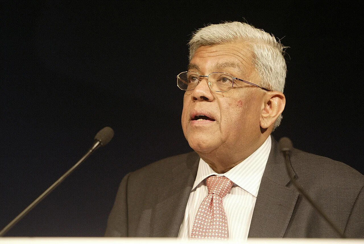 Deepak Parekh speaking between microphones at the 39th St. Gallen Symposium in 2009, with the complete supplied stage portrait and lectern edge.