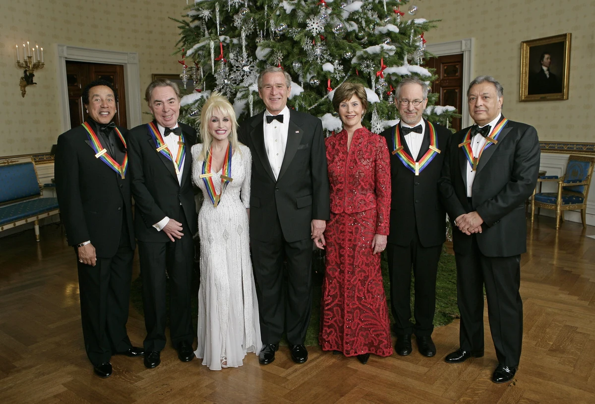 Dolly Parton, third from left in white, with the other 2006 Kennedy Center honorees, President George W. Bush and Laura Bush in the White House Blue Room; the entire seven-person group and room are retained.