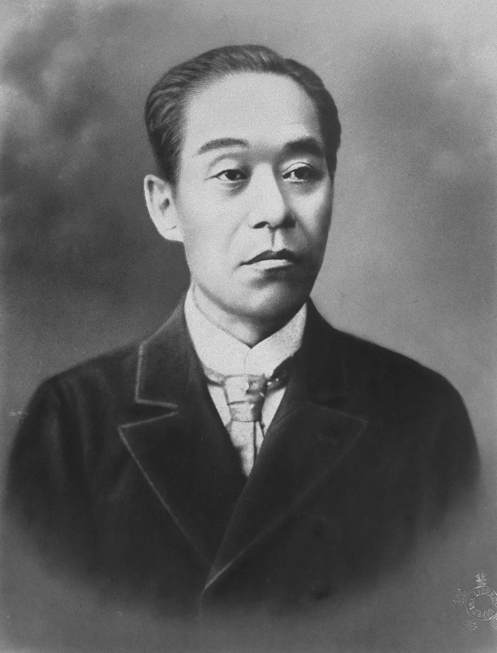 Formal photographic portrait of Fukuzawa Yukichi in a dark coat and pale cravat, taken before 1901.