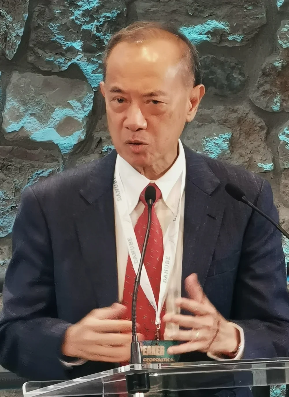 George Yeo speaking at a lectern at the 2025 Geopolitical Summit in Budapest.