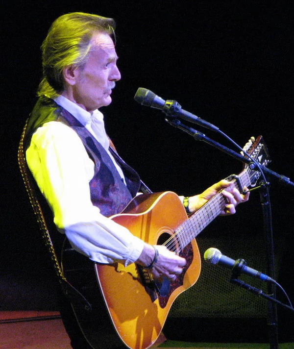 Gordon Lightfoot playing acoustic guitar and singing at Massey Hall in Toronto