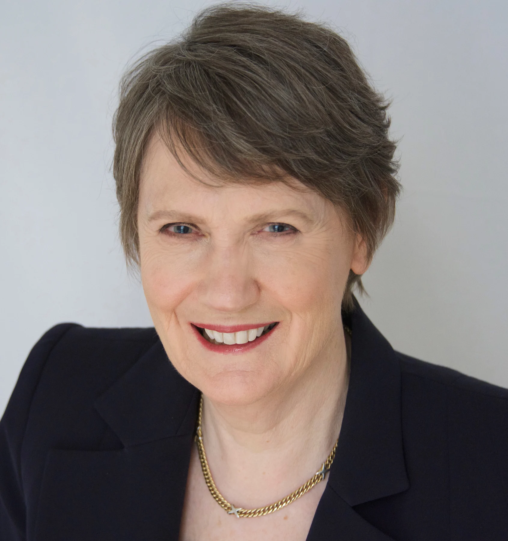 Helen Clark smiling in a dark jacket and necklace against a pale background, official photograph from 2016.