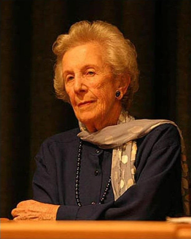 Helen Suzman seated with a scarf and her hands resting in front of her.