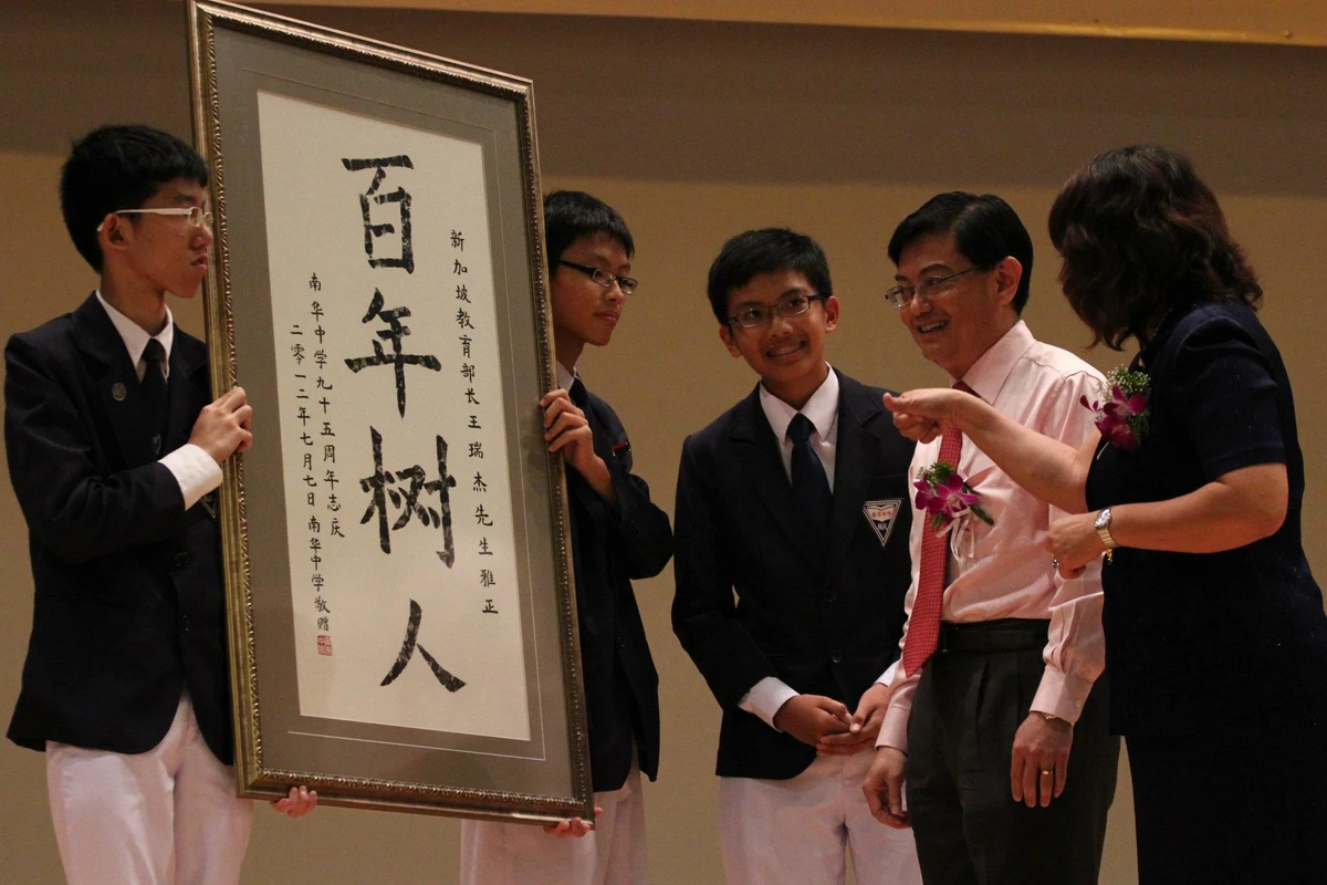 Heng Swee Keat receiving calligraphy from Nan Hua High School students in July 2012; complete supplied group photograph.