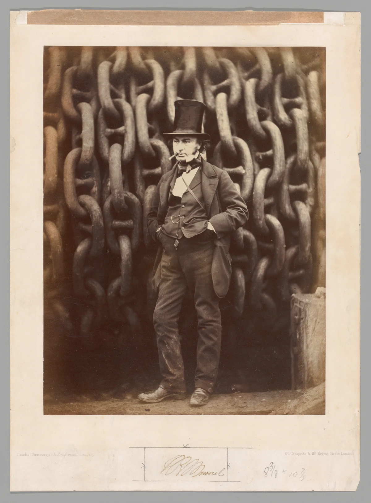Isambard Kingdom Brunel in a top hat before the Great Eastern’s launching chains; complete albumen photograph and historical mount with margins, signature and inscriptions.