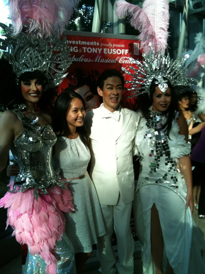 Ivan Heng, centre in a white suit, posing with audience members and performers after La Cage at Esplanade Theatre in July 2012.