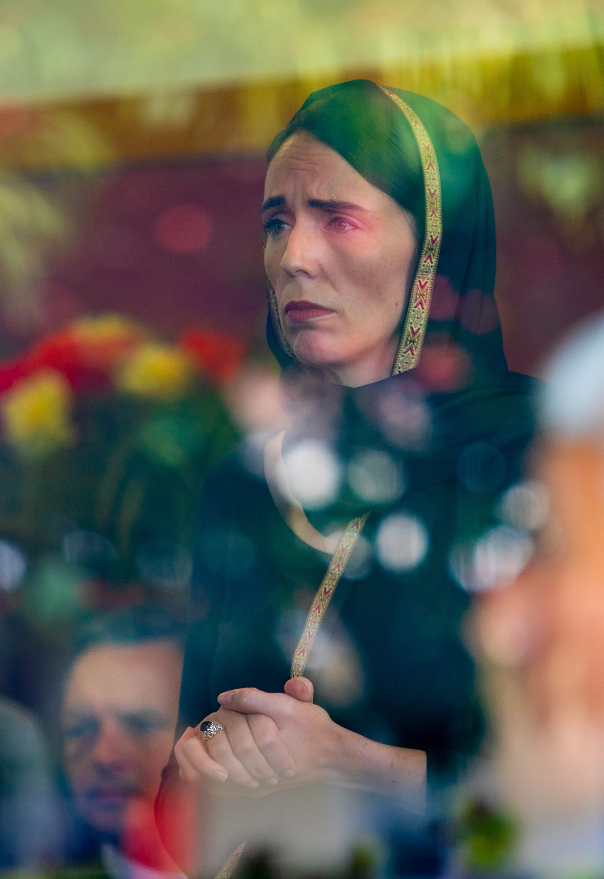 Jacinda Ardern visiting the Muslim community at the Phillipstown Community Centre, Christchurch, 16 March 2019; reflections on the window and James Shaw in the background.