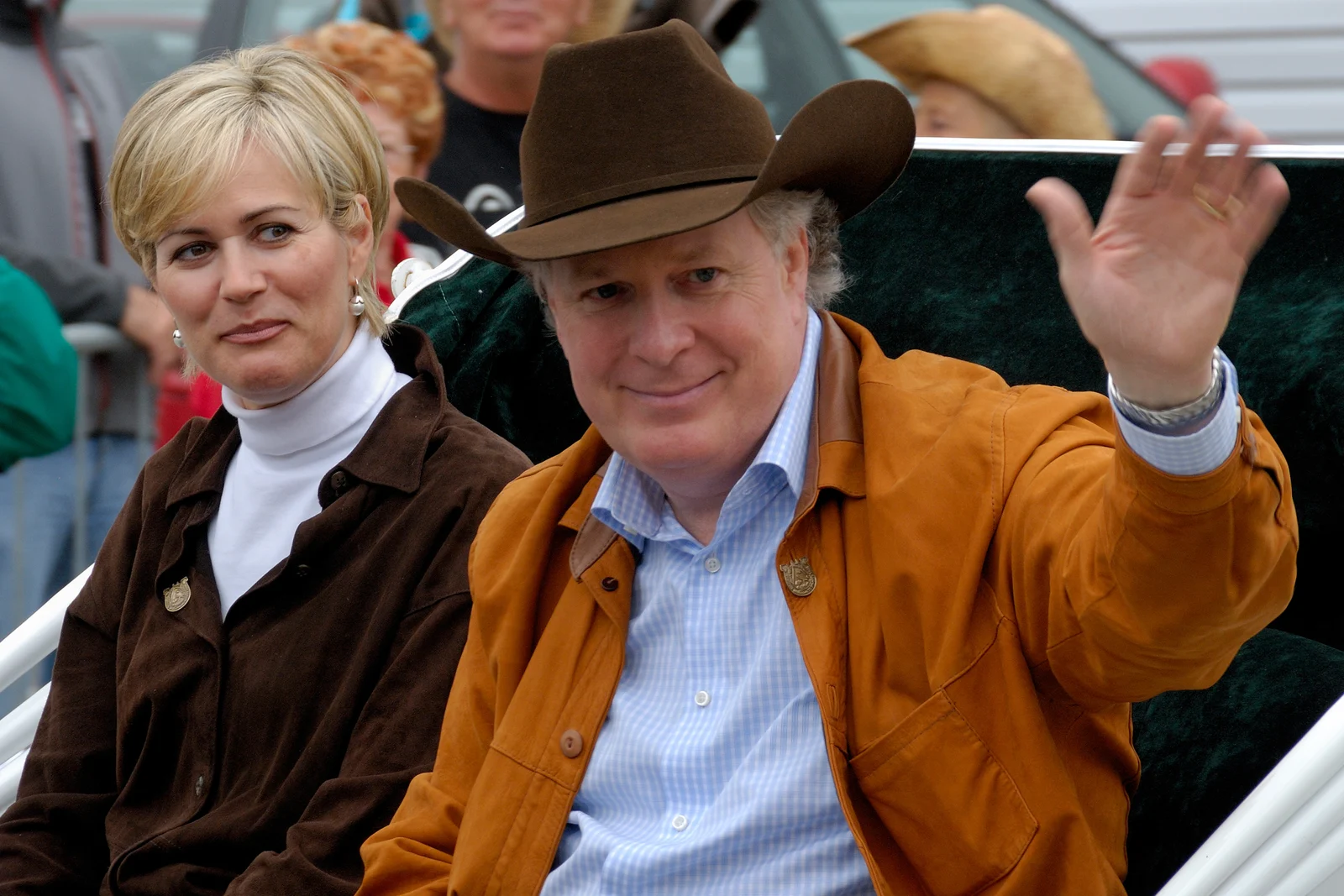 Jean Charest wearing a cowboy hat and waving beside Michèle Dionne in a carriage at Saint-Tite in September 2008