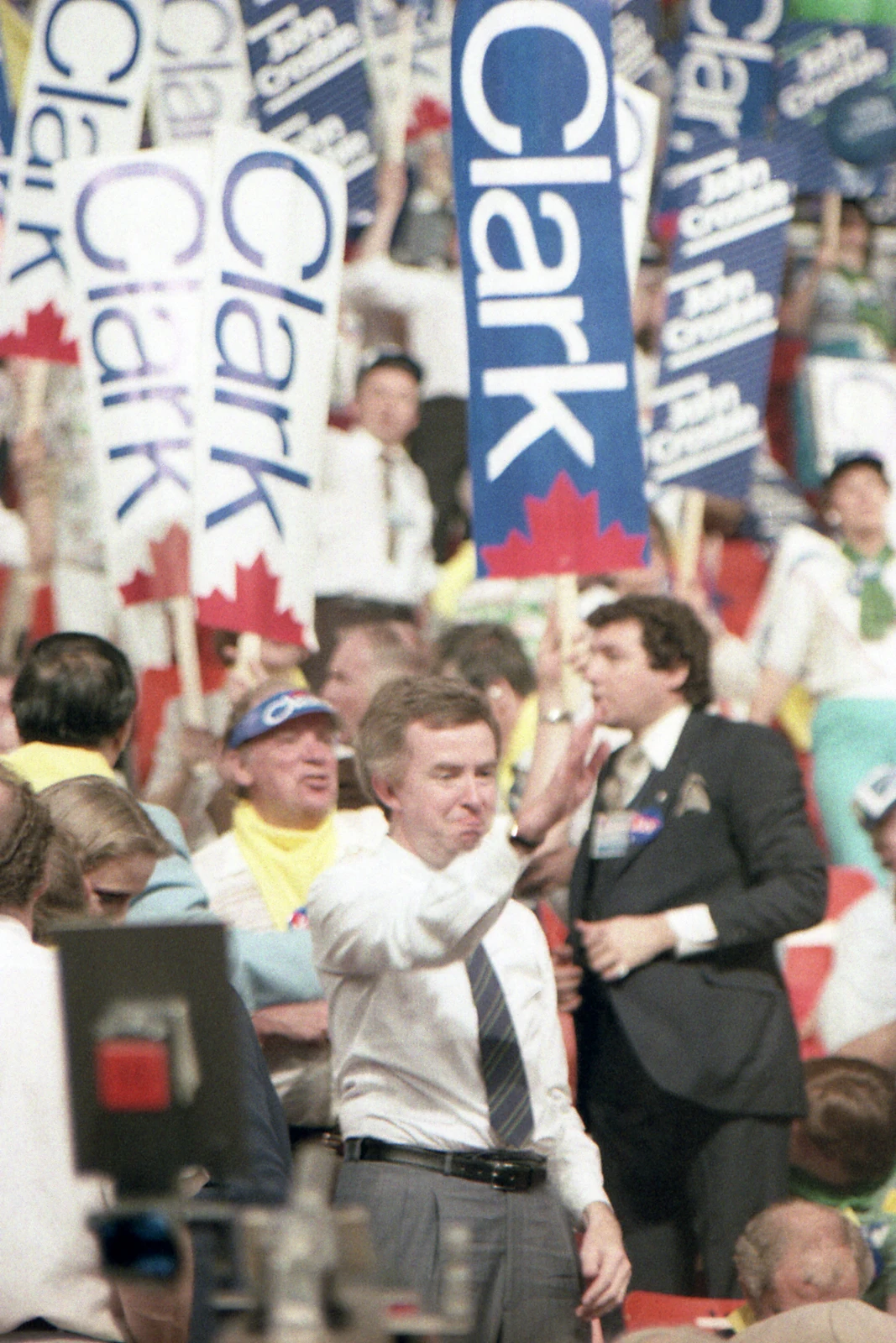 Joe Clark raising his hand among supporters holding Clark signs at the 1983 Progressive Conservative leadership convention