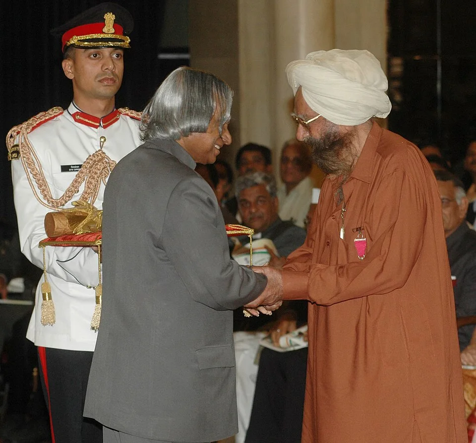 Khushwant Singh at right receiving an award from President A. P. J. Abdul Kalam, with an aide and audience retained