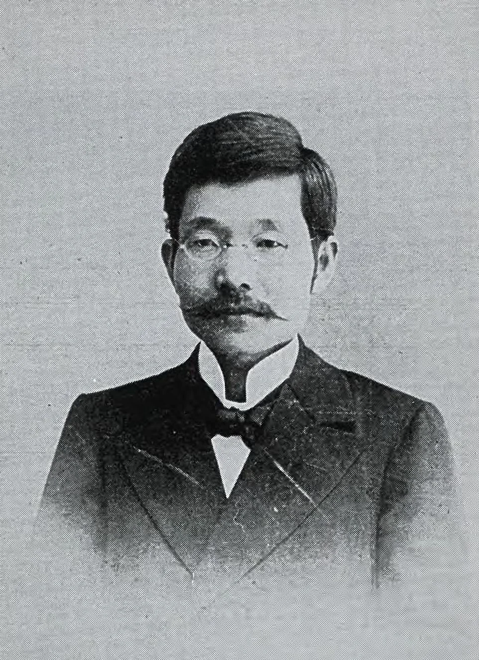 Kikunae Ikeda with a moustache, wearing a dark suit and bow tie in a historical portrait.