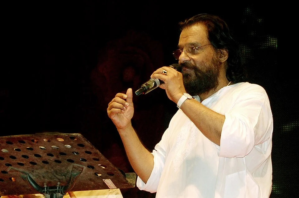 K. J. Yesudas singing at right of the complete frame, with microphone and music stand at left retained