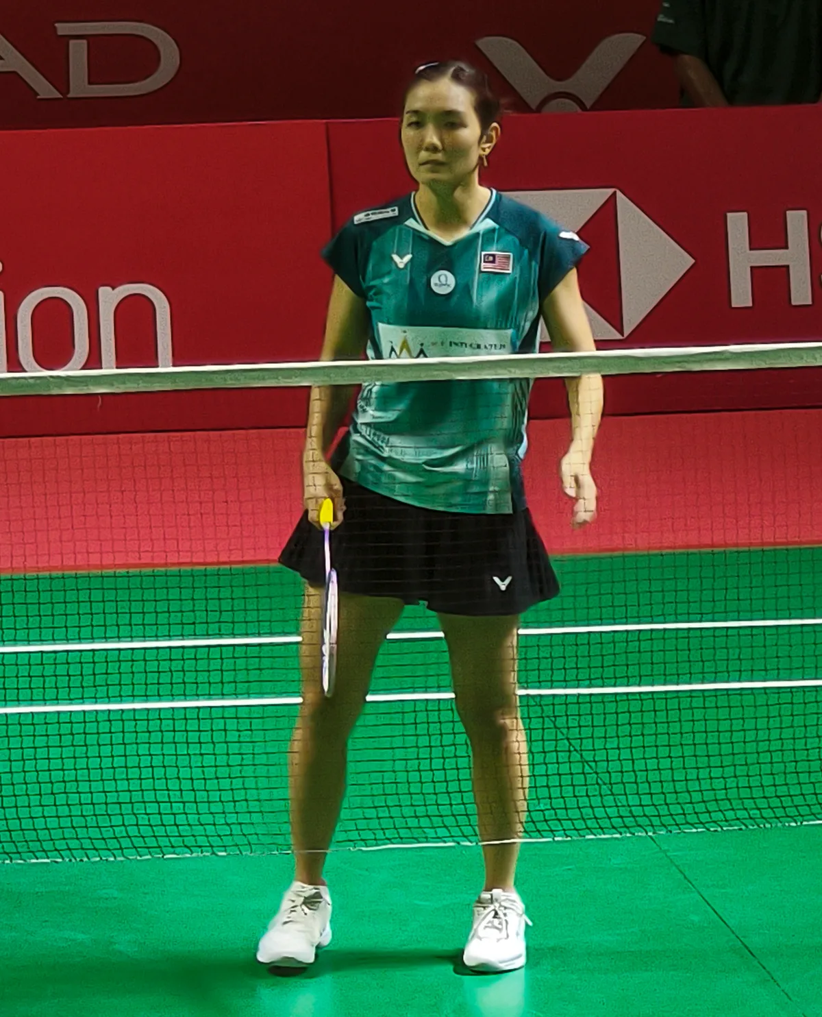 Lai Pei Jing standing behind the net in a teal Malaysia shirt at the 2026 Indonesia Open in Jakarta
