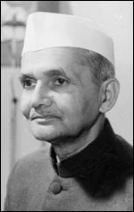 Lal Bahadur Shastri wears a white cap and dark high-collared coat in the complete small photograph supplied by the Prime Minister’s Office.