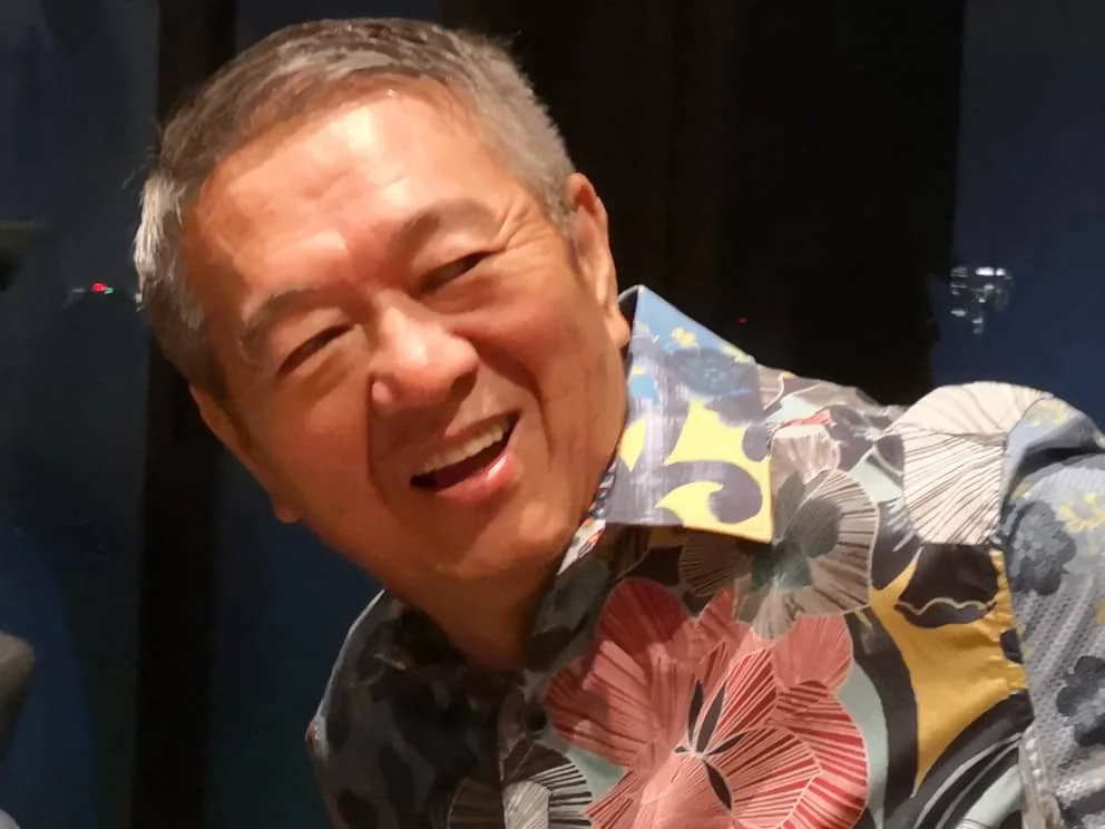 Lee Kim Yew smiling in a patterned shirt in a December 2018 photograph.