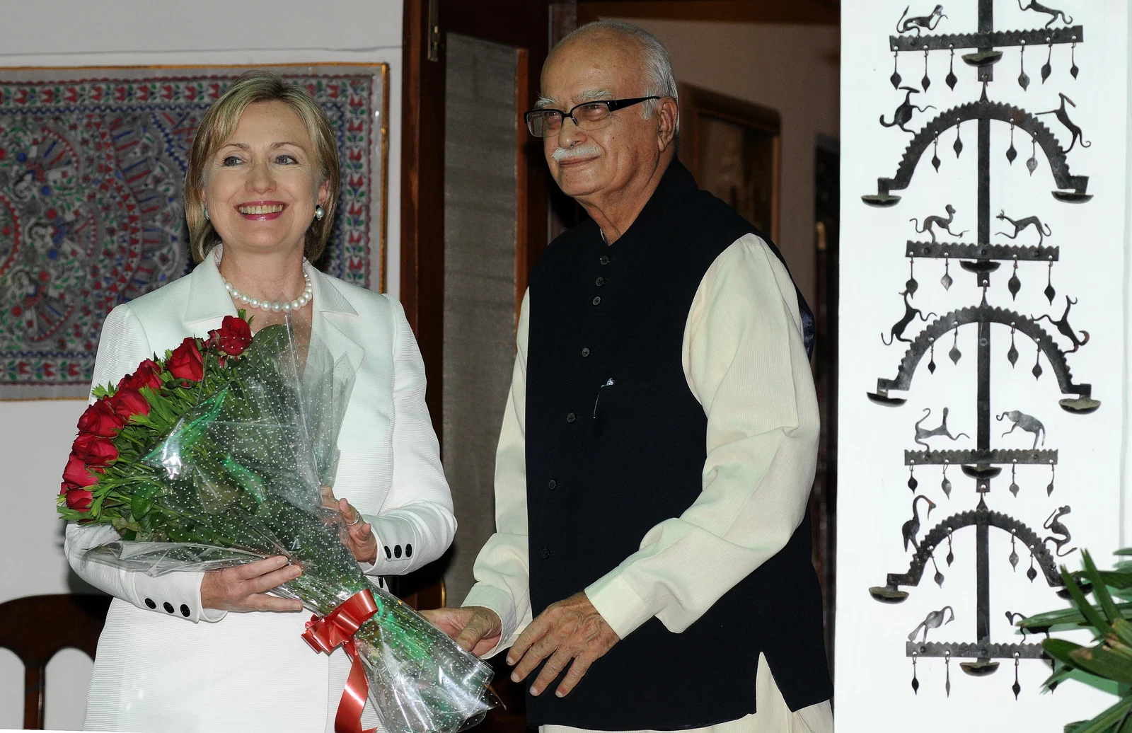 L. K. Advani at right welcomes Hillary Clinton, holding flowers at left, in the complete frame outside his New Delhi residence in July 2009.