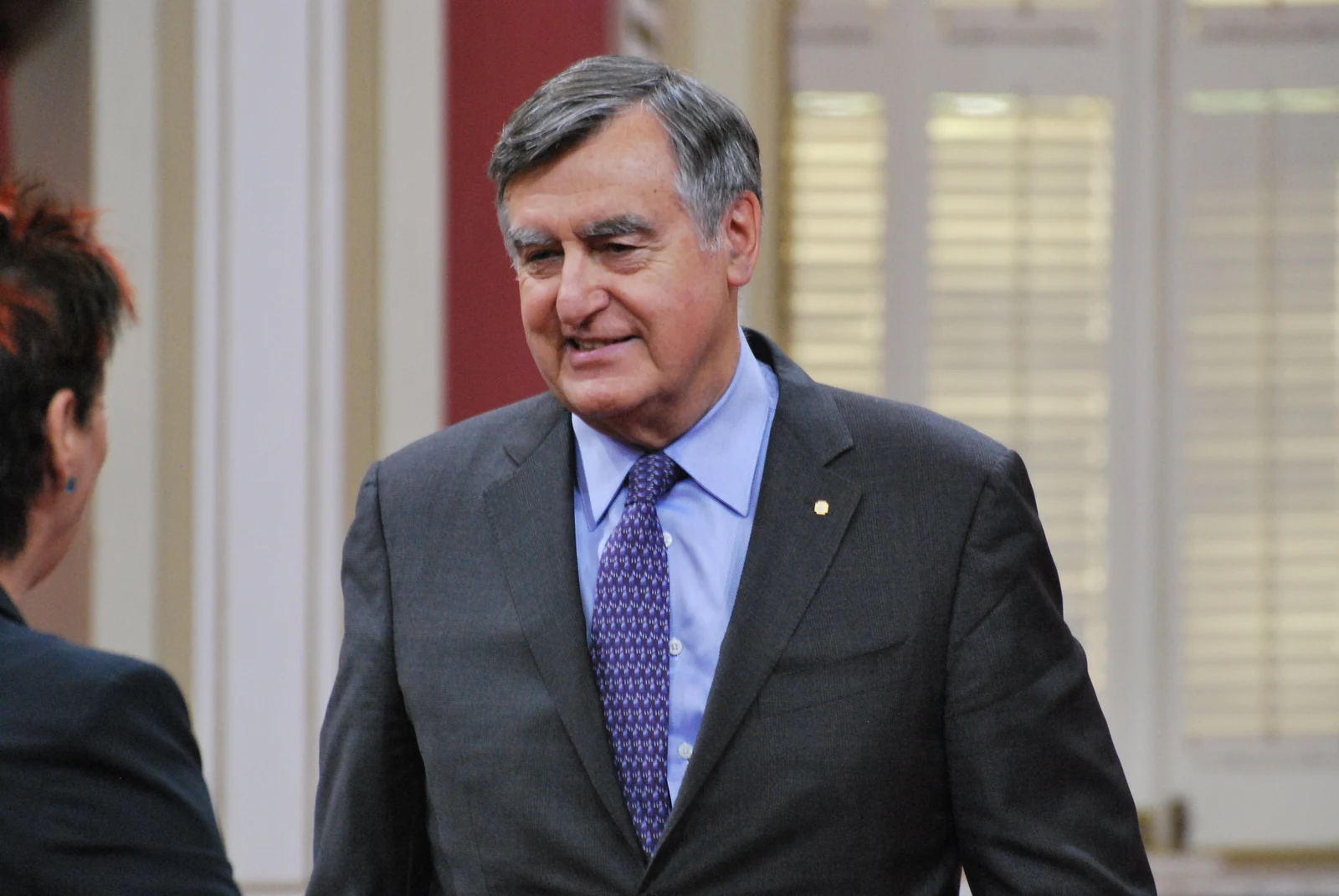 Lucien Bouchard in a dark suit speaking with another attendee at the 2013 Ordre national du Québec ceremony