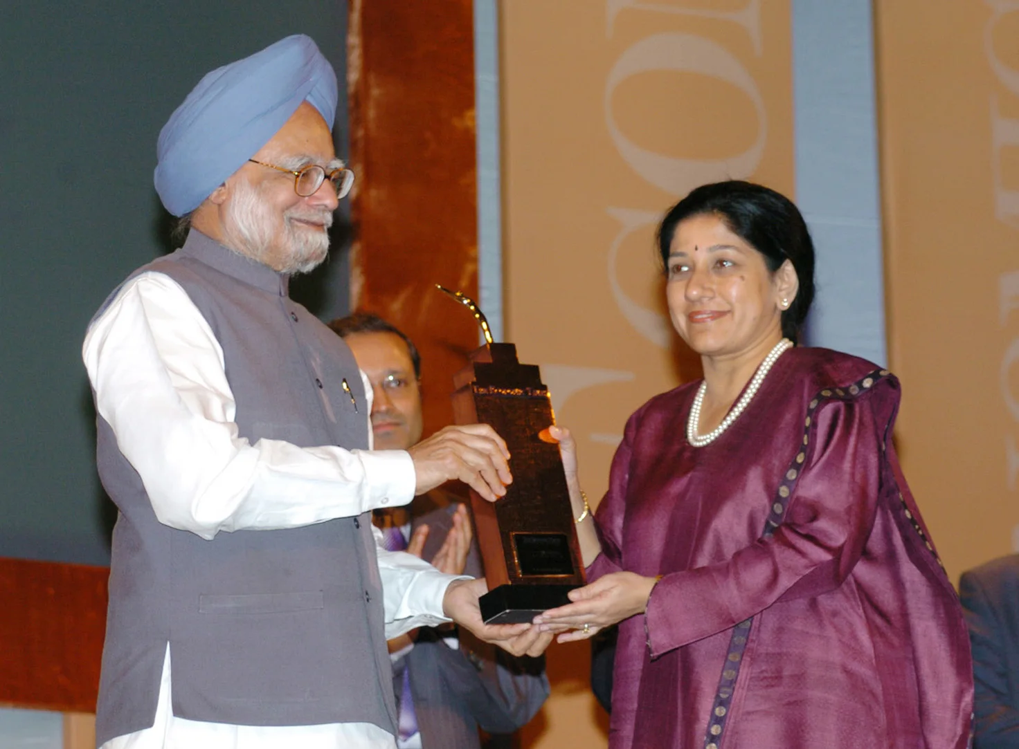 Mallika Srinivasan at right receives a business award from Prime Minister Manmohan Singh in Mumbai in October 2006; the complete frame is retained.