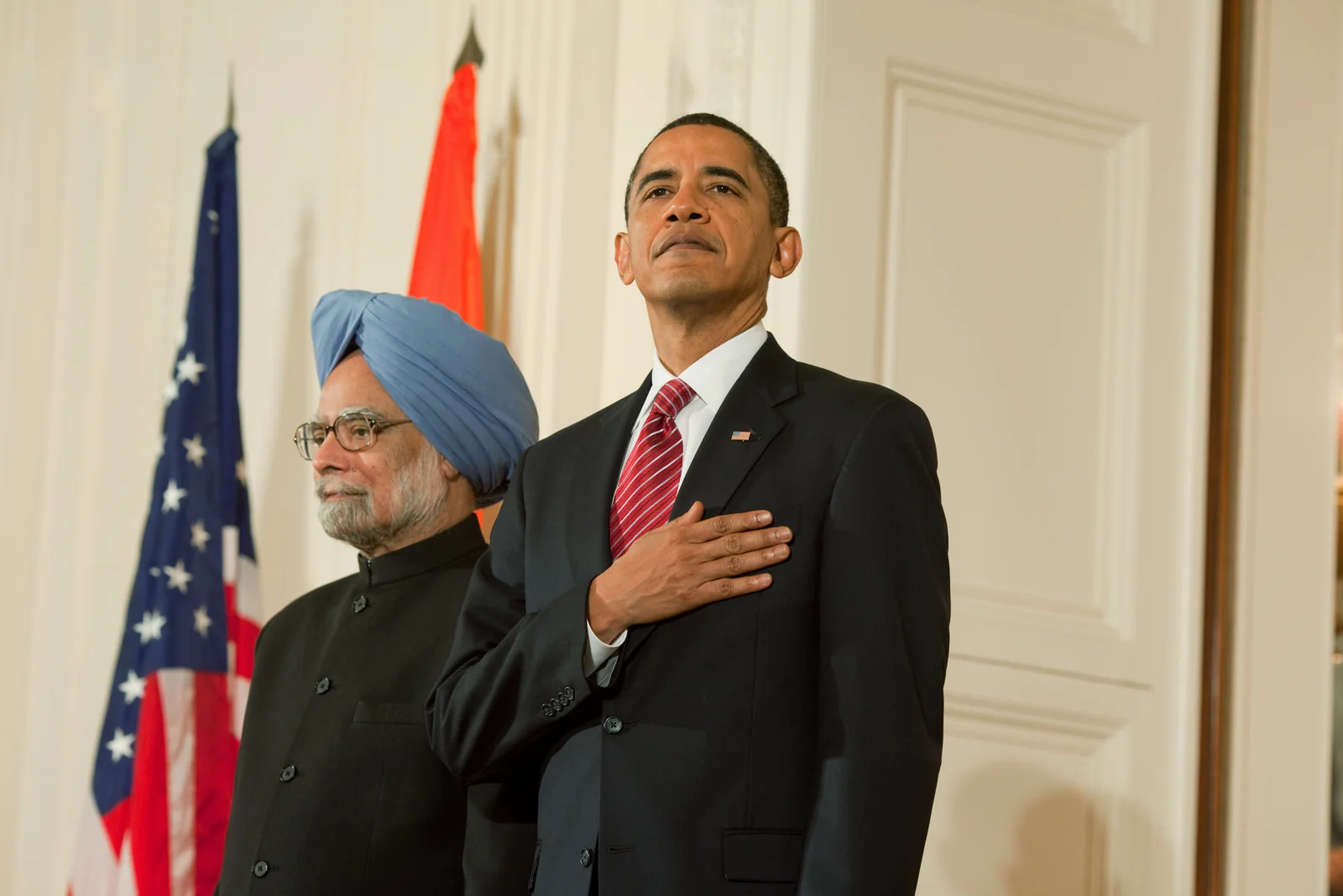 Manmohan Singh at left and Barack Obama at right stand for an anthem in the White House East Room in November 2009.