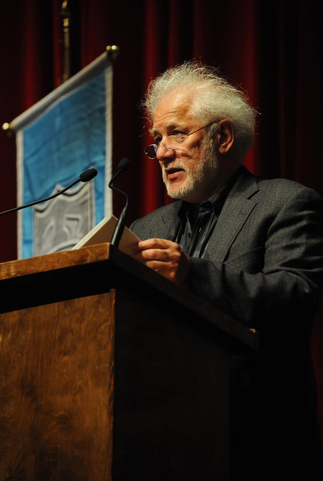 Michael Ondaatje reading at a wooden lectern at Tulane University in October 2010