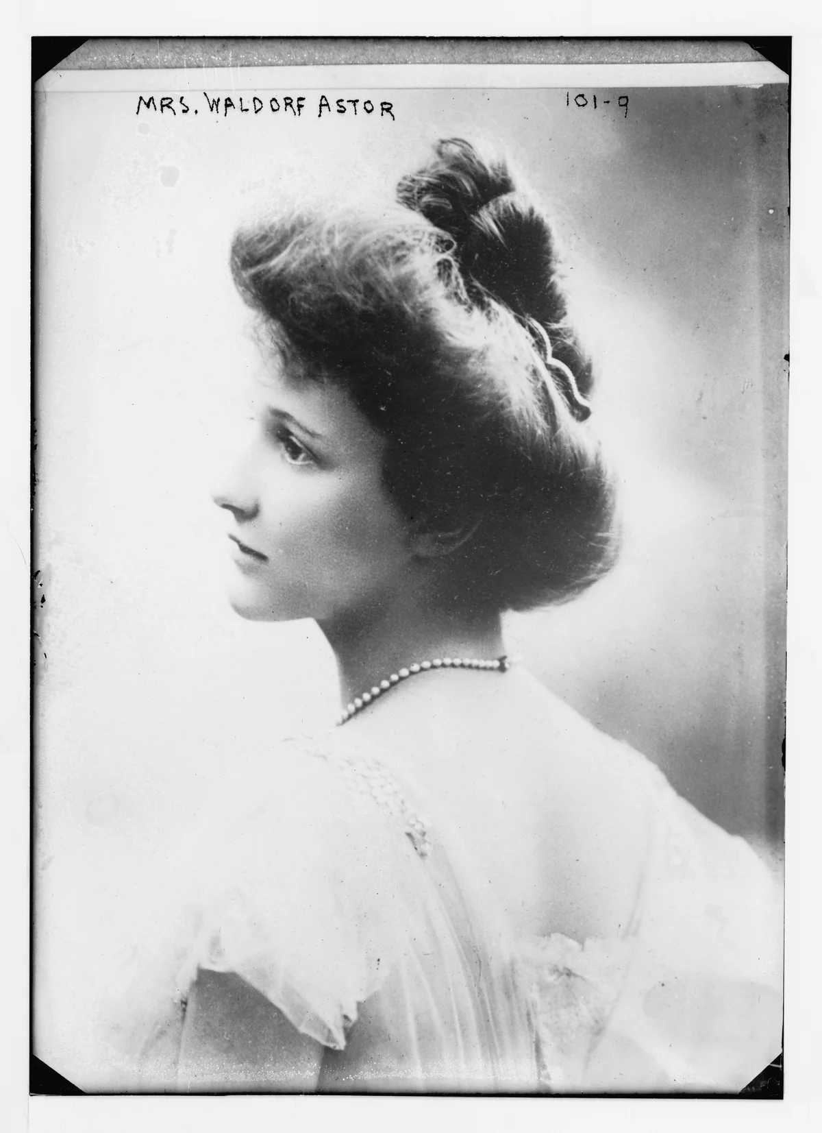 Nancy Astor in a profile portrait published in 1906, preserved within the full Bain glass-negative plate with its handwritten title and edges.