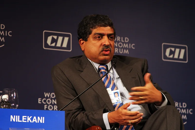 Nandan Nilekani seated and speaking at the India Economic Summit in New Delhi in December 2007, with the complete nameplate, microphone and forum backdrop.
