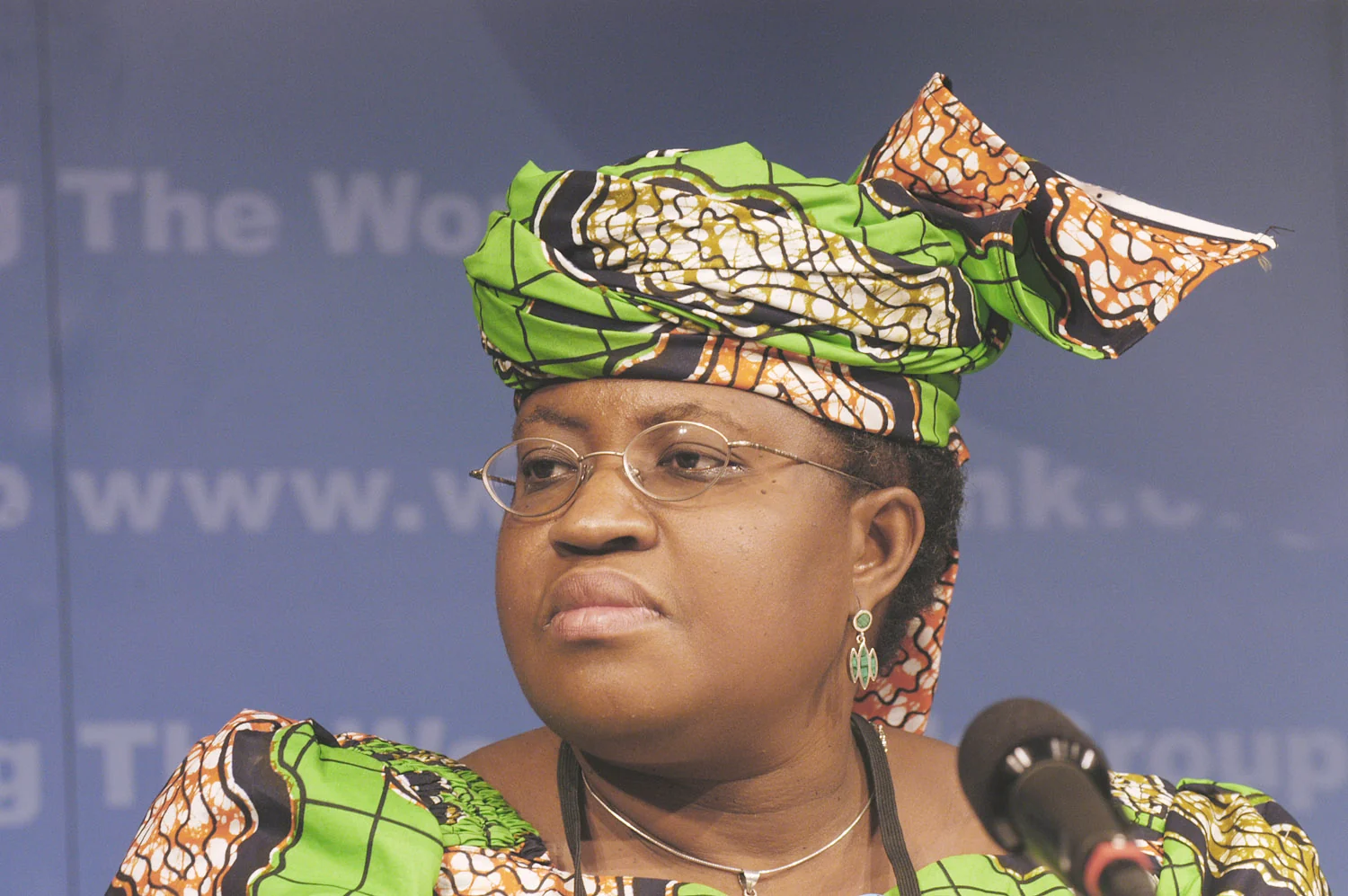 Ngozi Okonjo-Iweala at the IMF and World Bank Spring Meetings on 25 April 2004, wearing a patterned headwrap beside a microphone