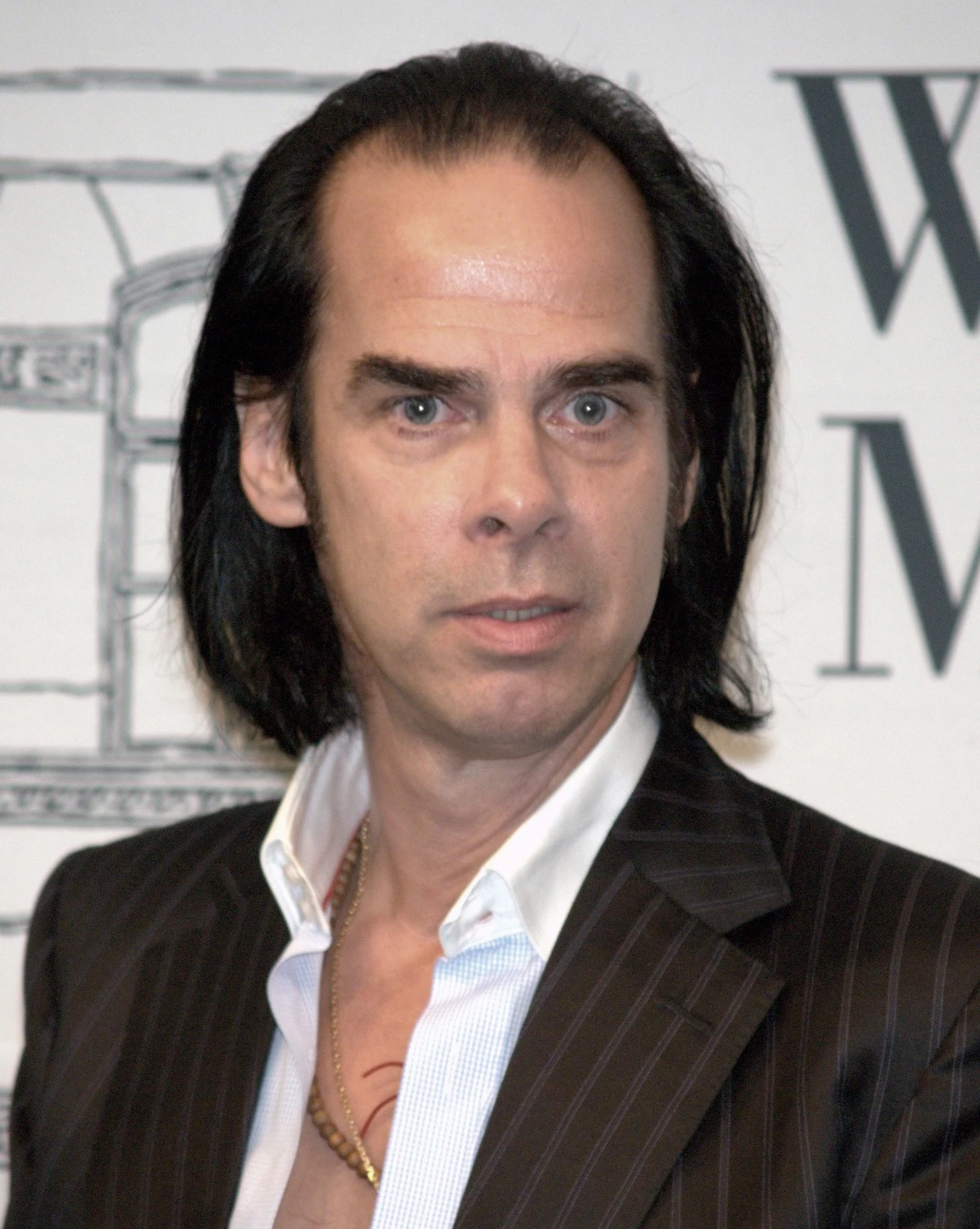 Nick Cave in a dark jacket and open-neck white shirt at a New York book event in September 2009
