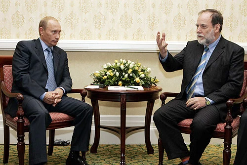 Complete 2006 Cape Town photograph: Nicky Oppenheimer sits at right gesturing, Vladimir Putin at left; both chairs and the flower-topped table retained.