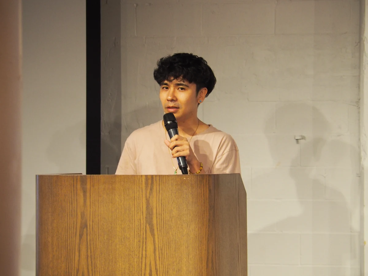 Ocean Vuong speaking into a microphone behind a podium, photographed on 4 August 2019.
