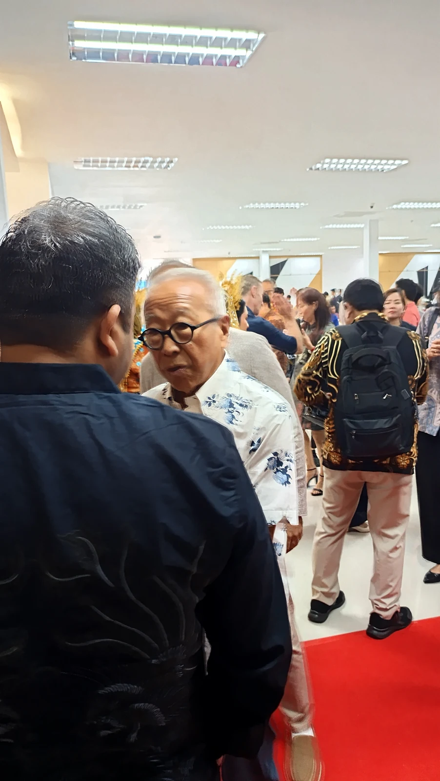 Ong Beng Seng, in a white floral shirt near the centre-left, speaking with another attendee at PT Volex Batam in August 2024.