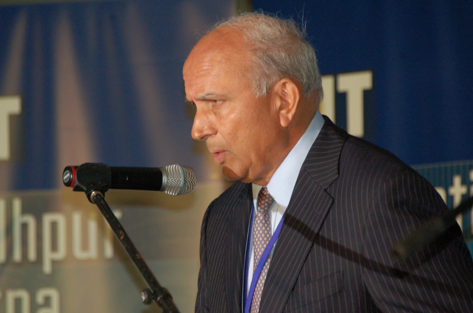 Prem Watsa speaking at a microphone at the Pan-IIT meeting in Toronto in June 2014, in the complete supplied photograph.