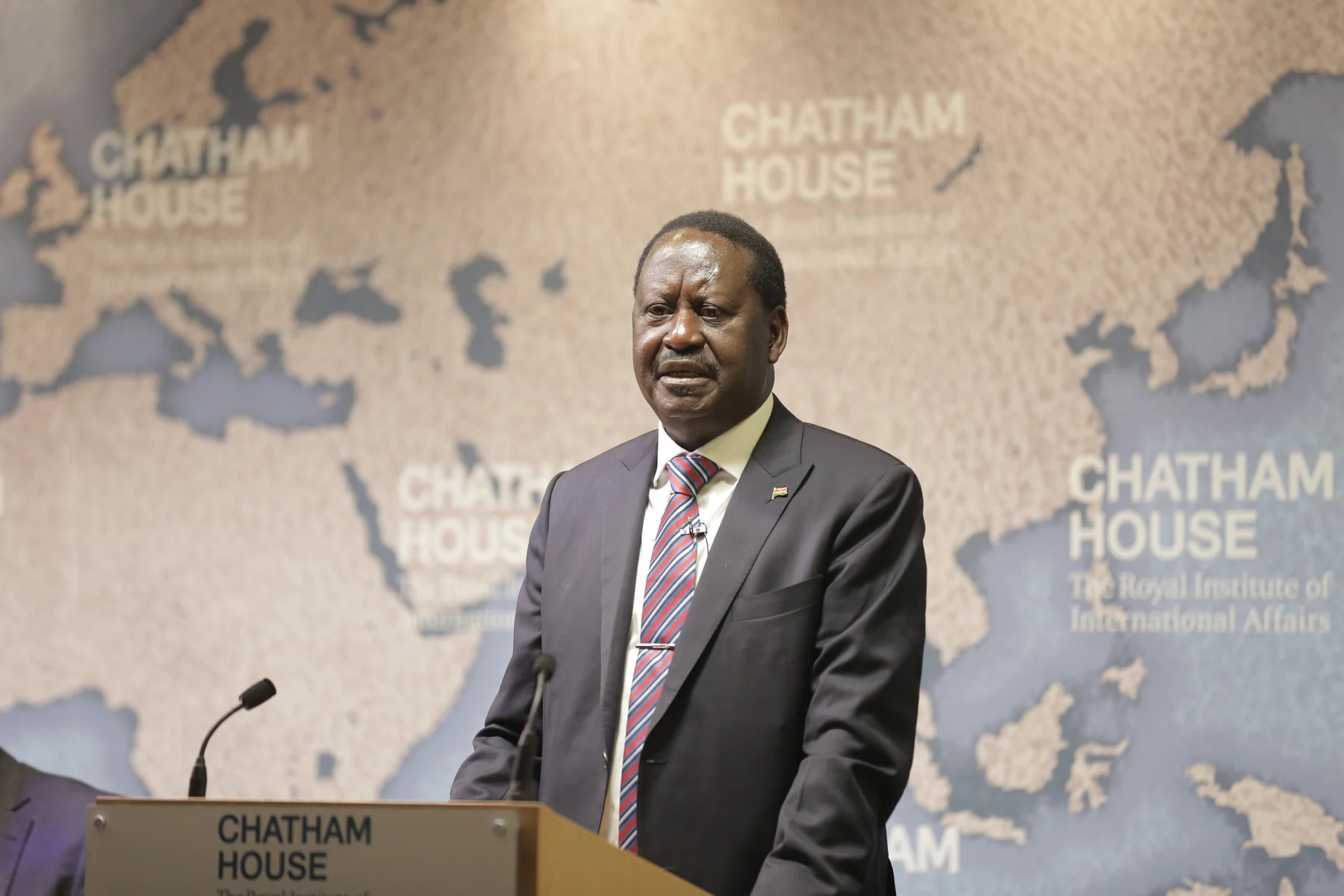Raila Odinga standing at a Chatham House lectern, with the complete supplied event backdrop.