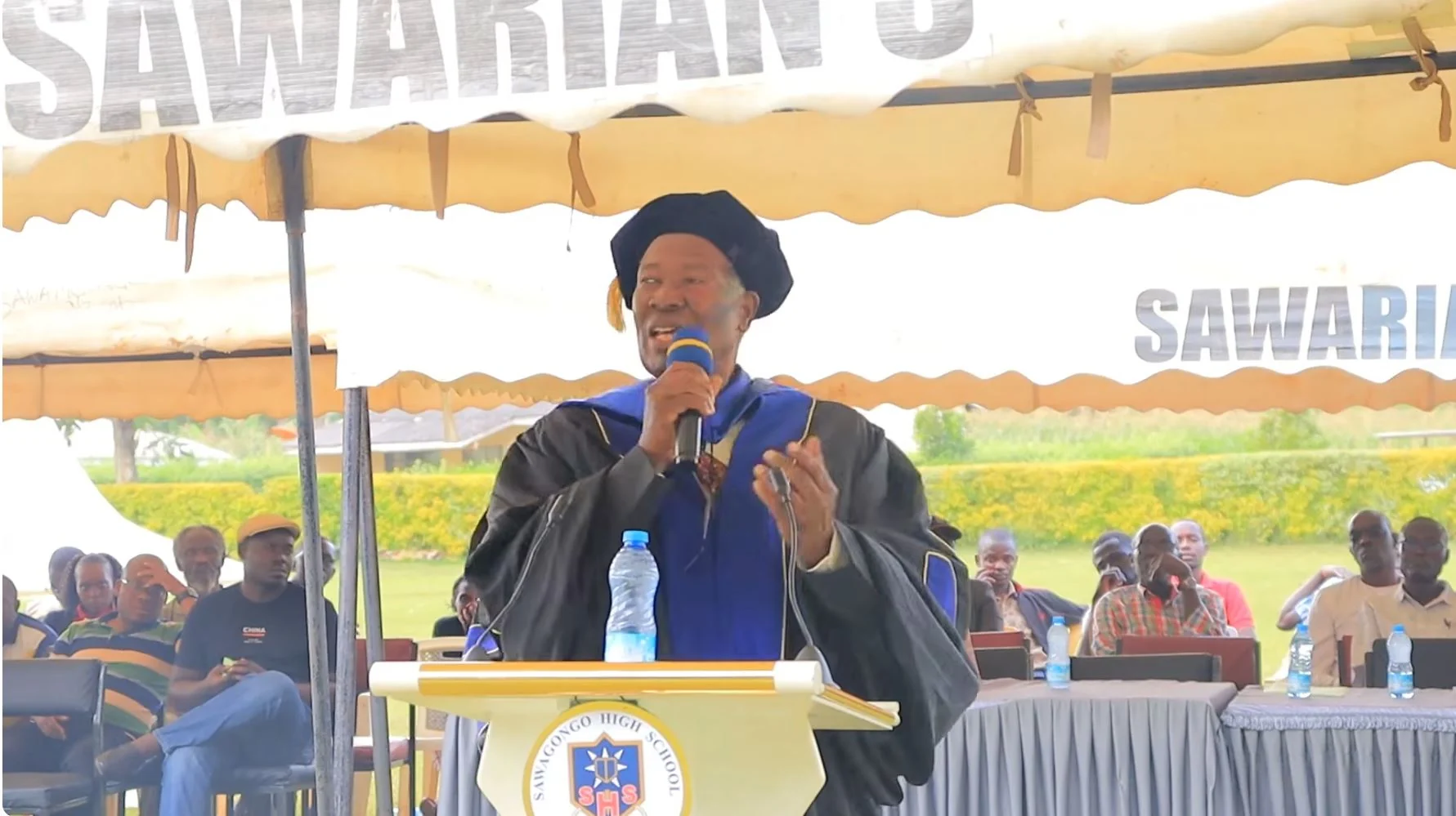 Ratemo Michieka speaking at Sawagongo with other participants;complete supplied image.