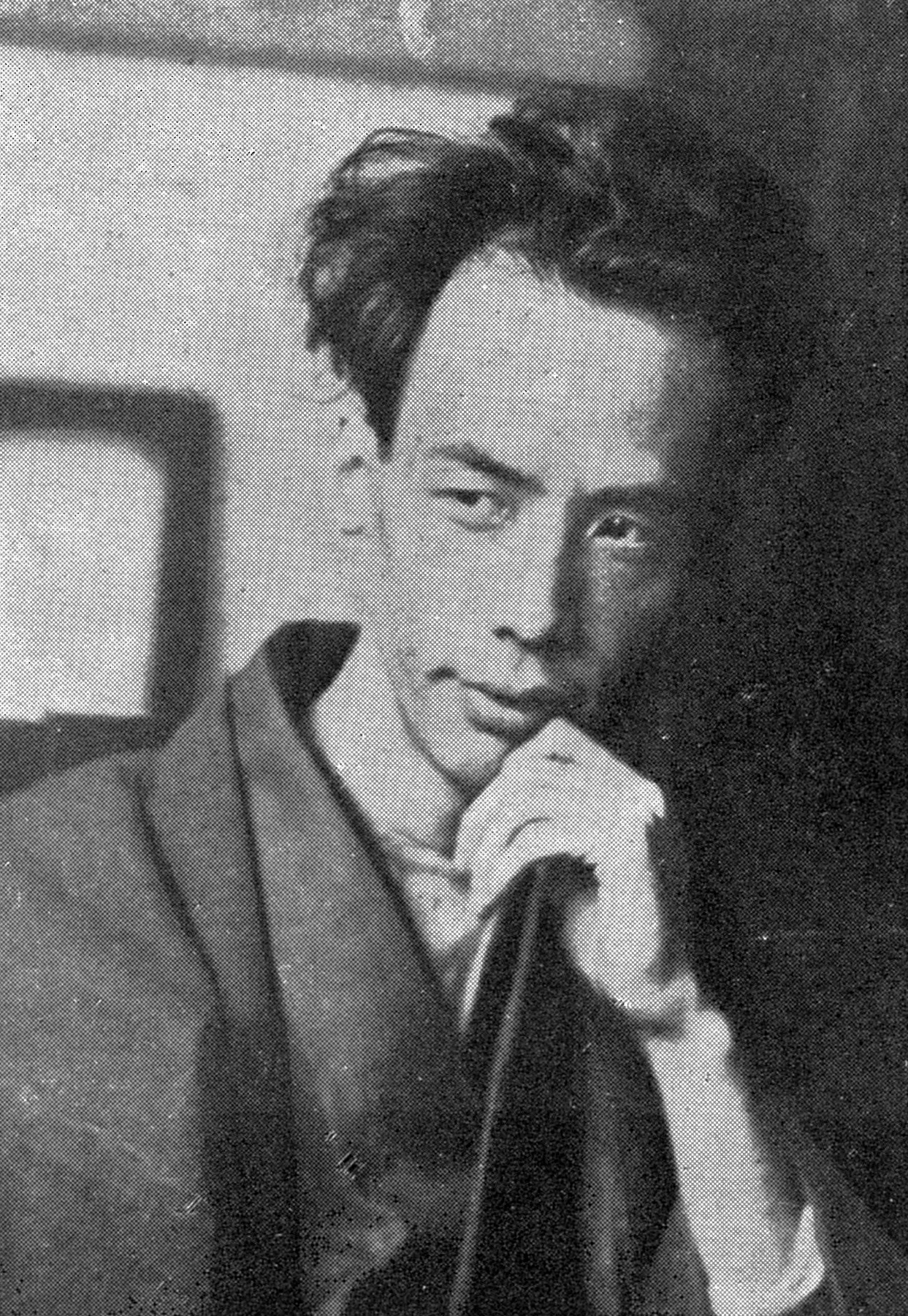 Ryūnosuke Akutagawa seated in traditional clothing with a hand beside his chin, photographed in 1927.