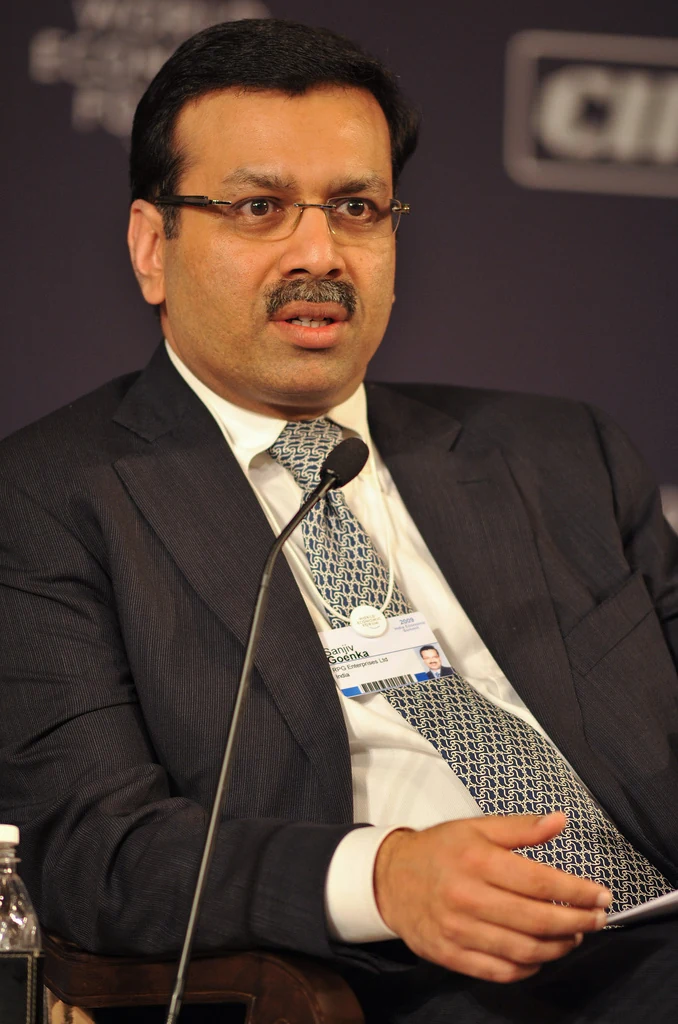 Sanjiv Goenka seated at a microphone at the World Economic Forum India Economic Summit in November 2009; his conference badge is visible.