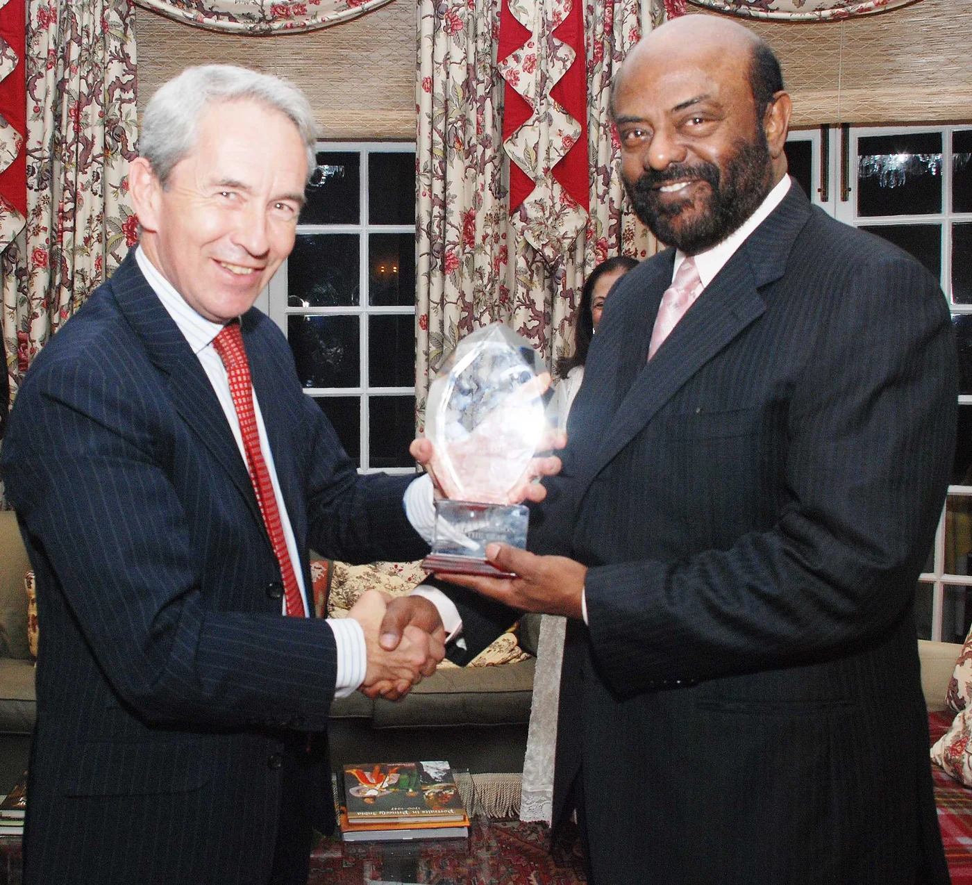 Shiv Nadar on the right receiving an award with British High Commissioner Richard Stagg on the left in 2009; a third person is partly visible behind them.