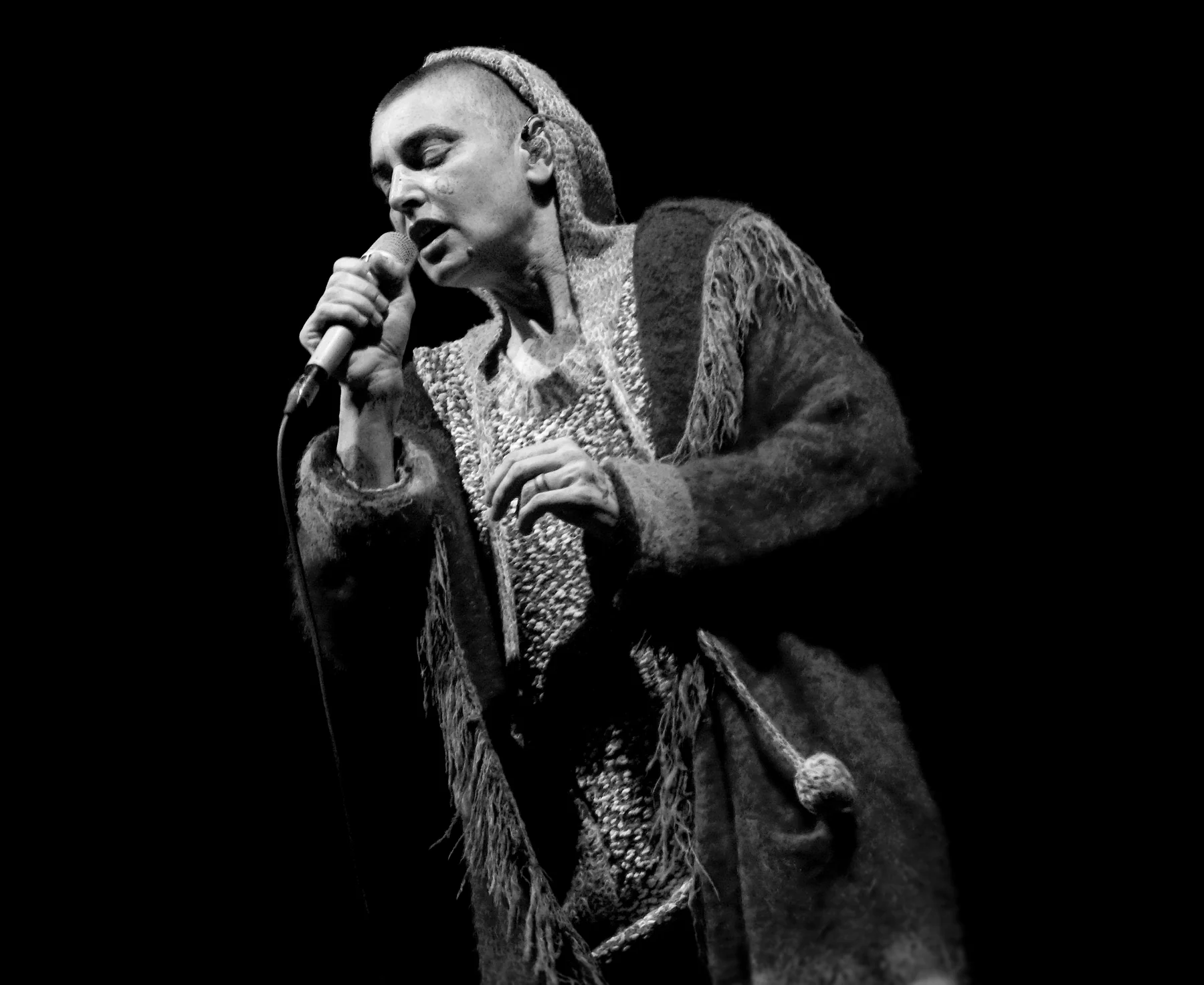 Sinéad O’Connor performing in the complete supplied 2013 concert photograph.