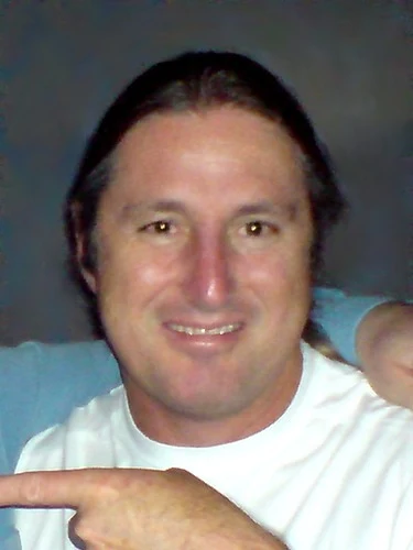 Tim Winton in a white T-shirt at the 2008 London launch of Breath; the supplied frame retains another attendee’s arm